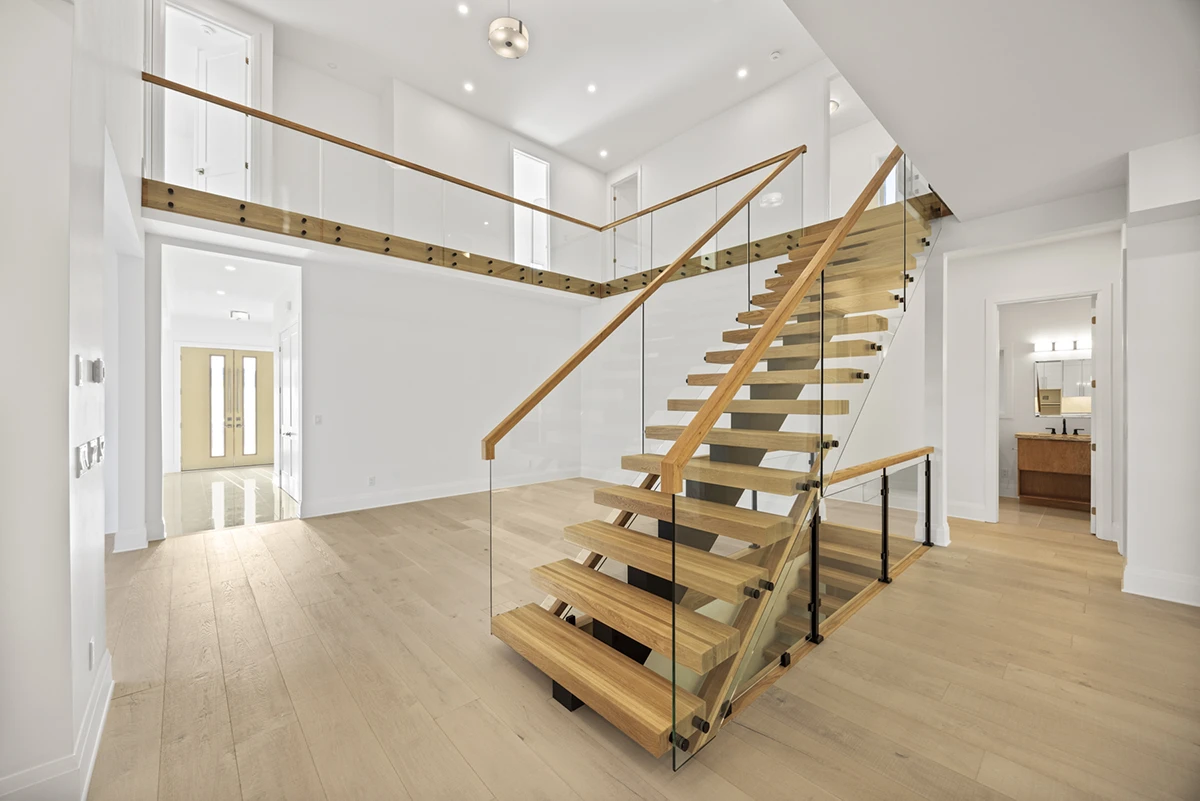 Contemporary floating staircase overlooking an open-concept living space.