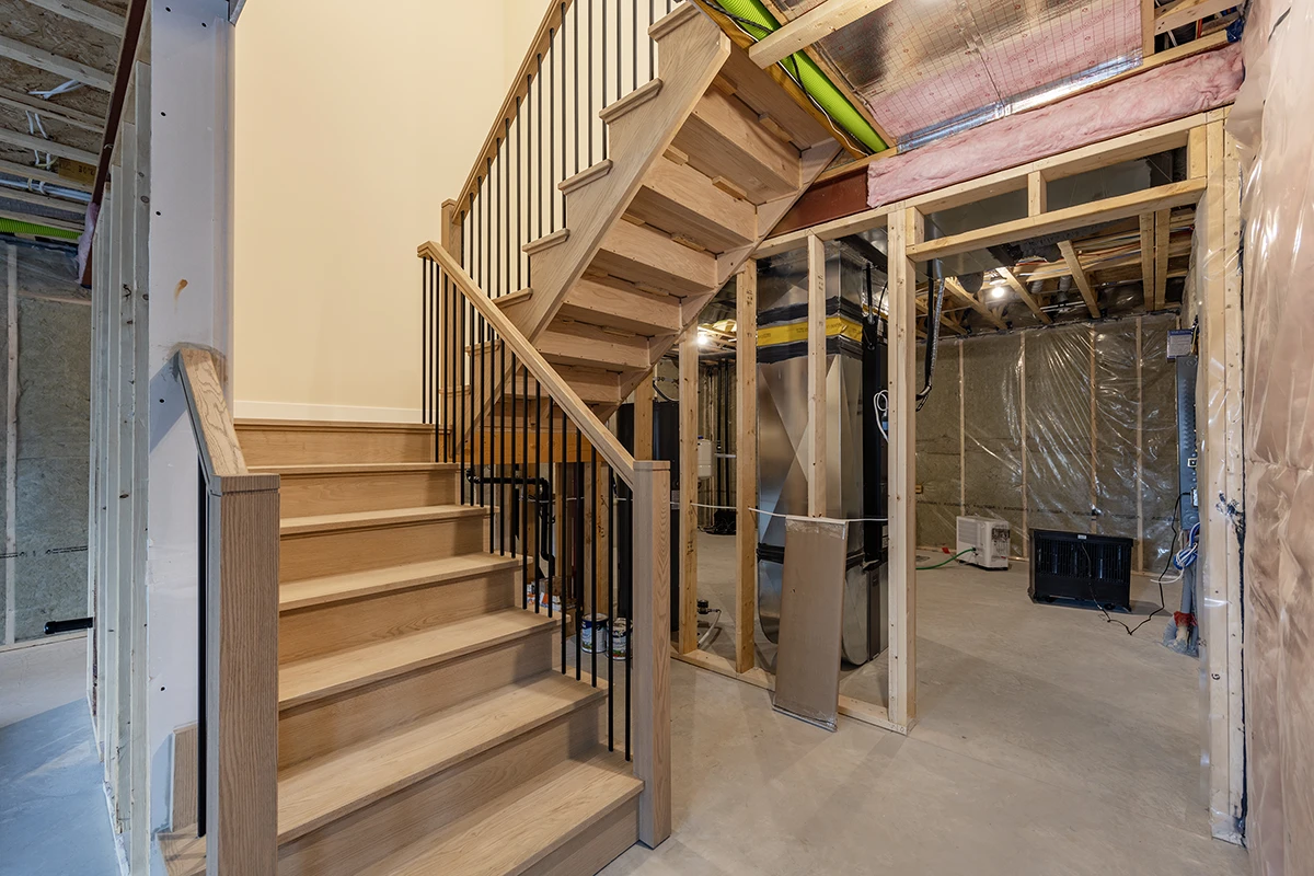 Staircase under construction with unfinished wood treads.
