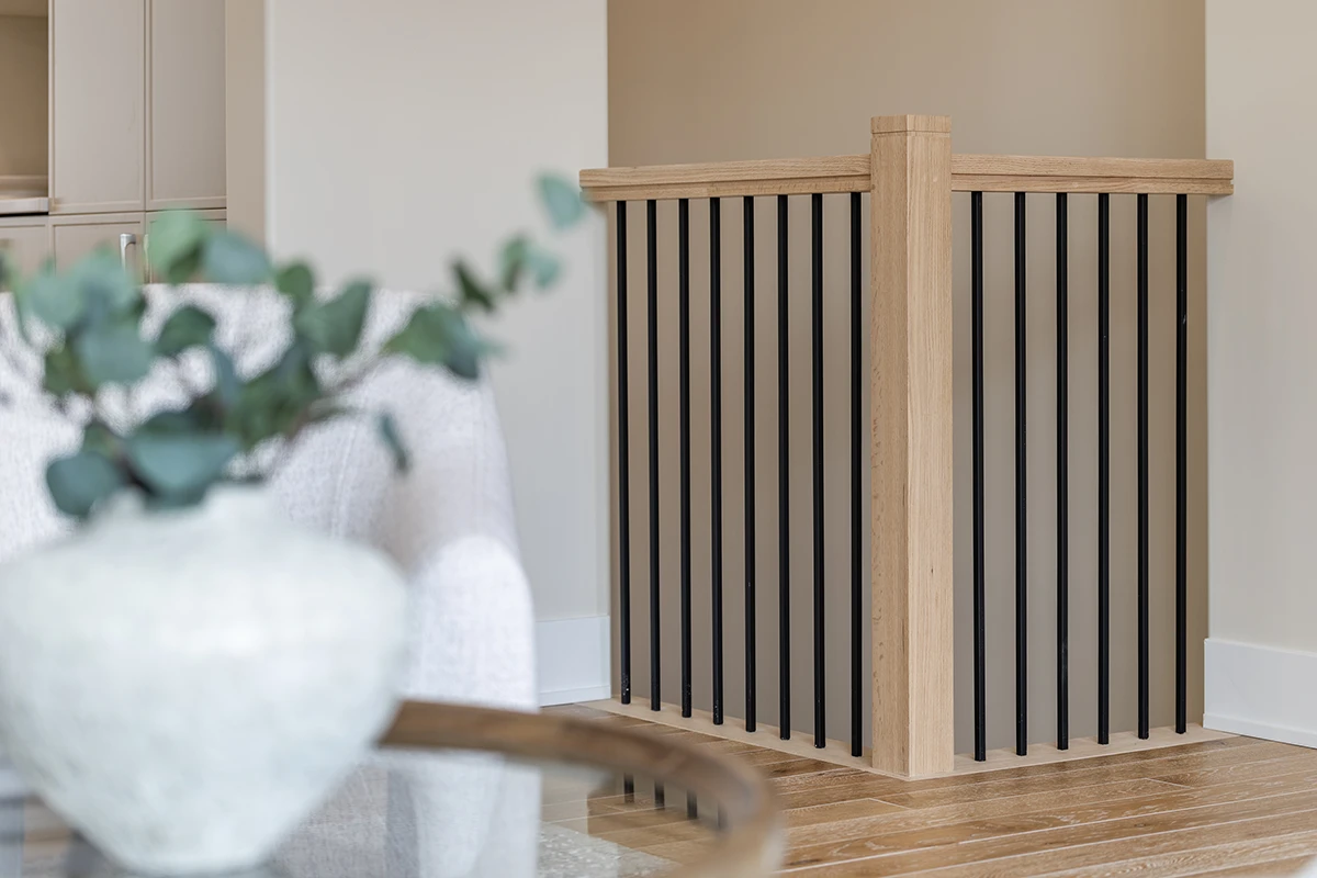 Square wood newel post with black metal balusters.
