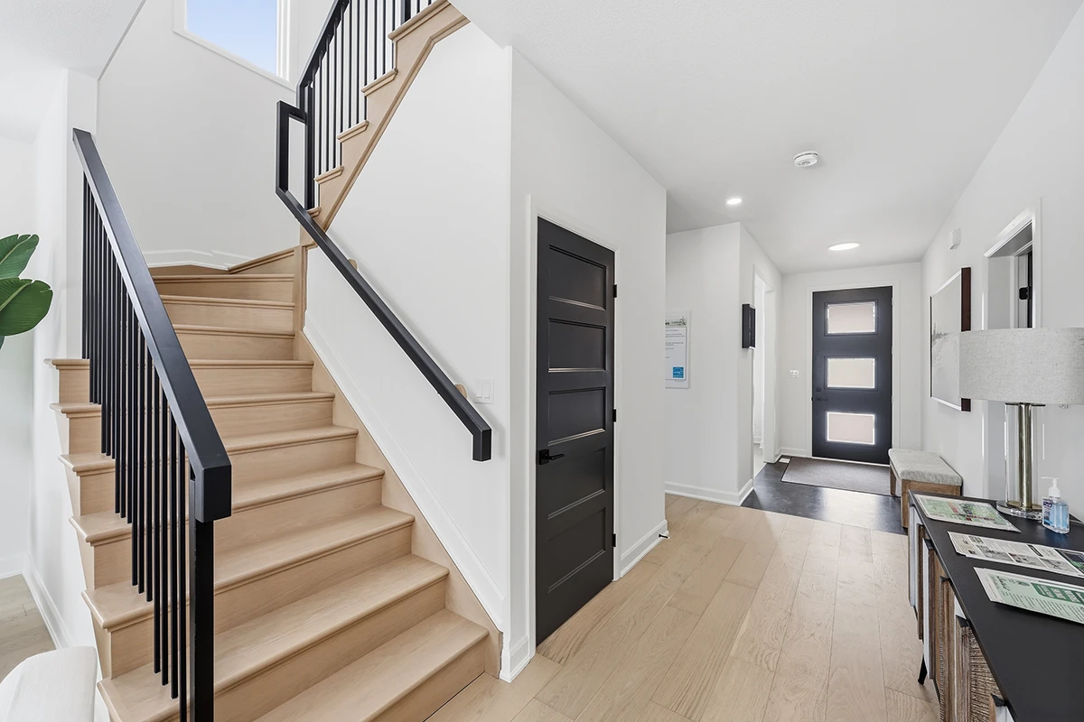 Contemporary staircase with black metal railings and wood treads.