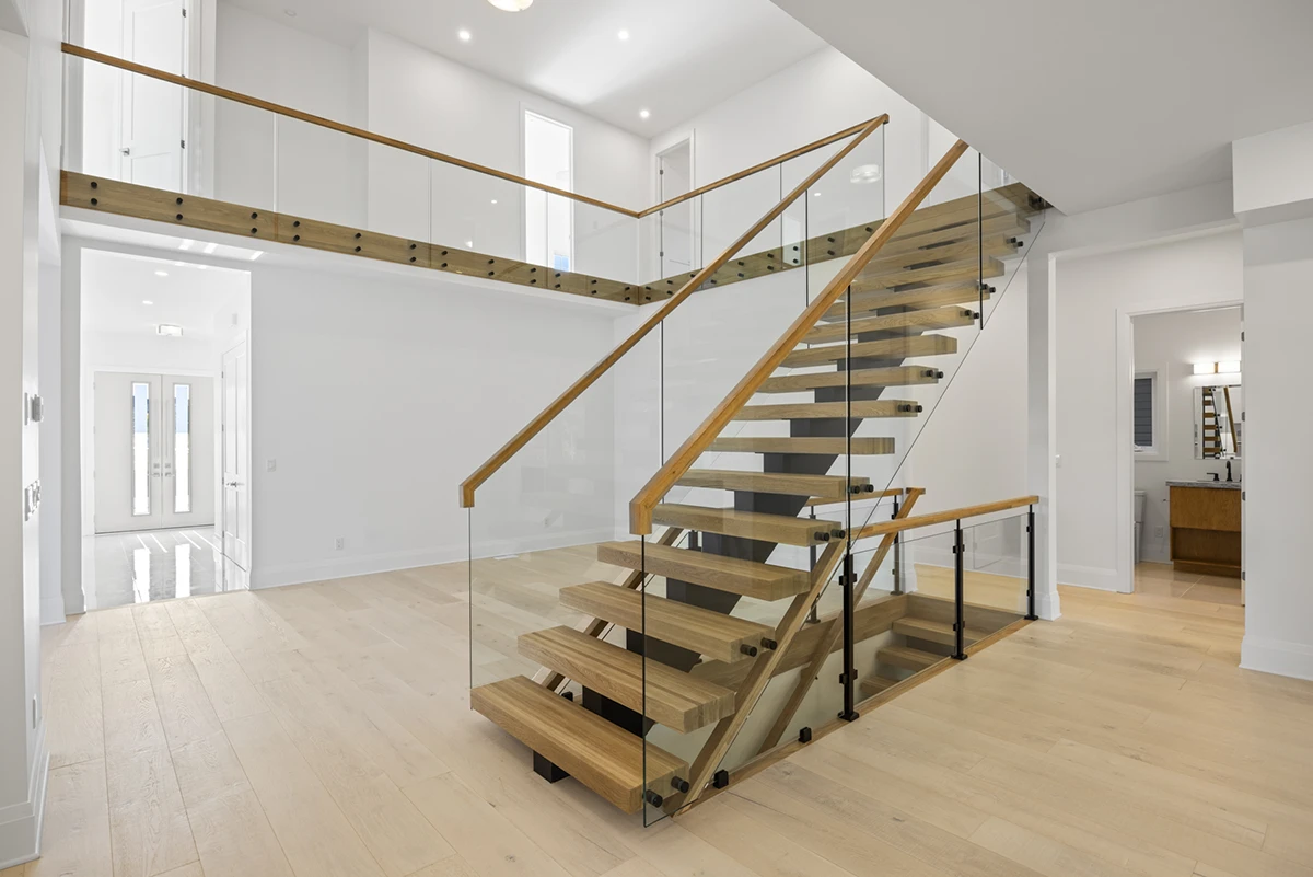 Floating staircase beside a contemporary kitchen with white cabinetry.
