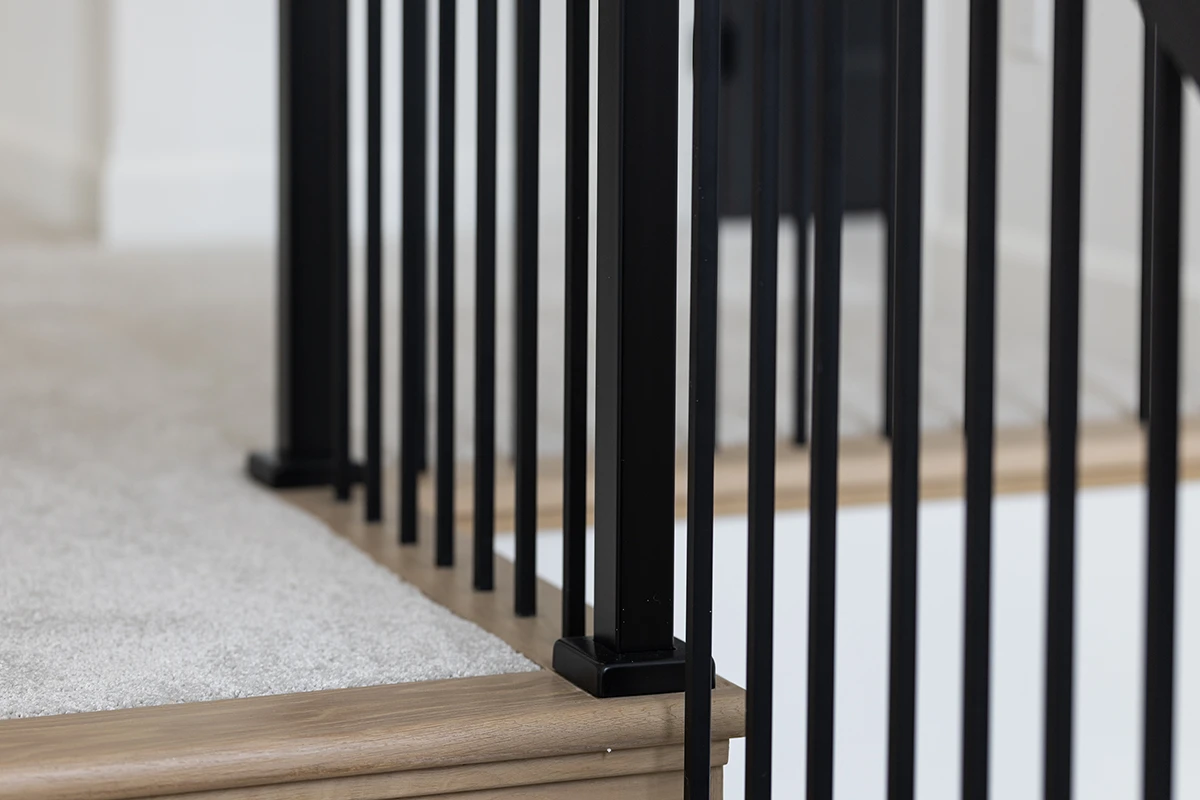 Close-up of black metal balusters on a finished staircase.