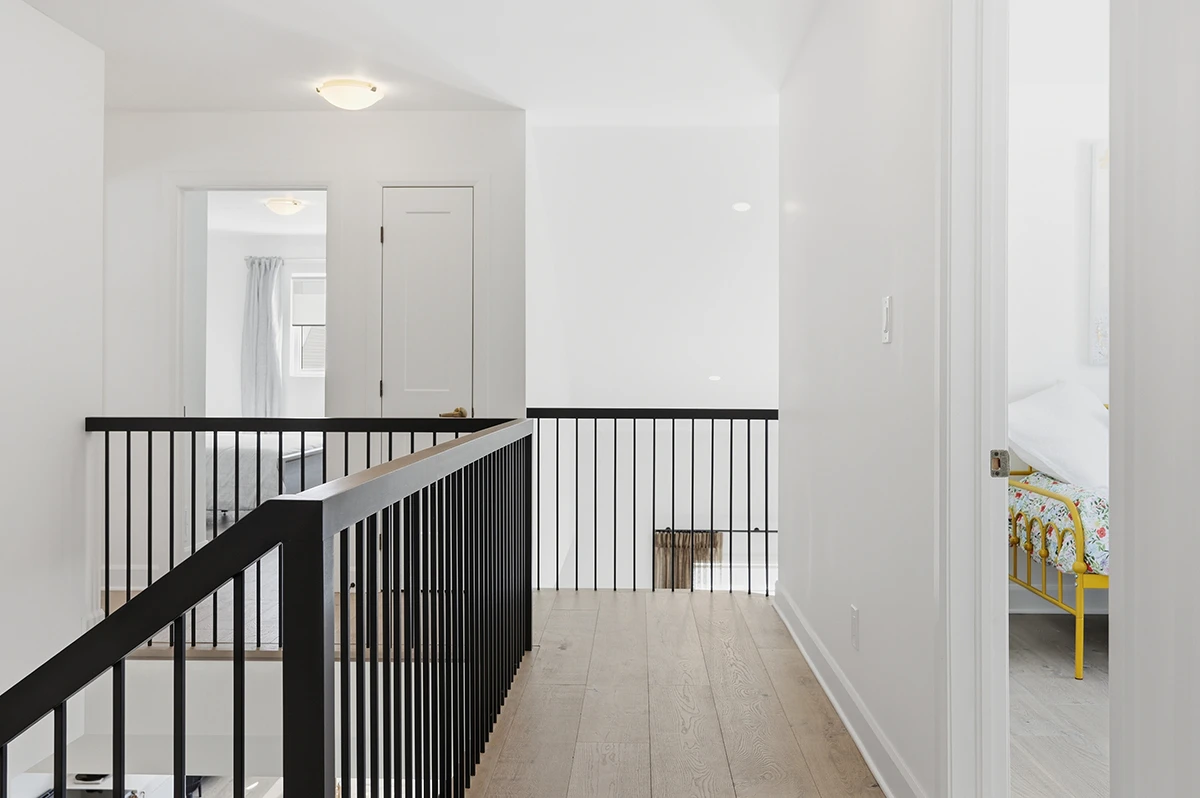 Upper hallway with black metal railings in a contemporary home.