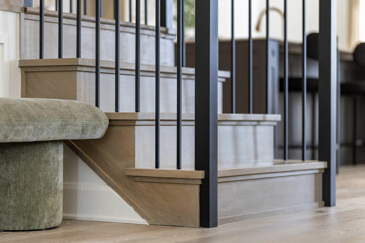 Wood staircase with black metal balusters and square newel posts.