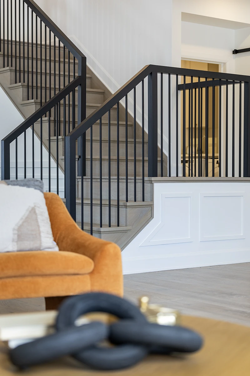 Black metal staircase railings in an open-concept home.