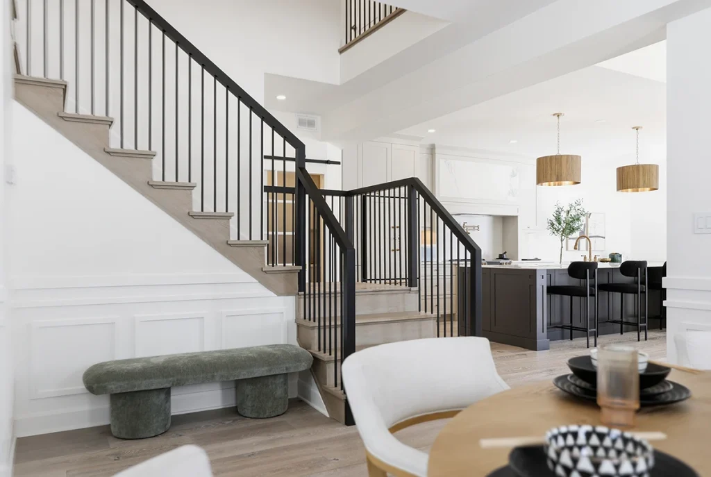 Contemporary staircase with black metal railings in a bright home.