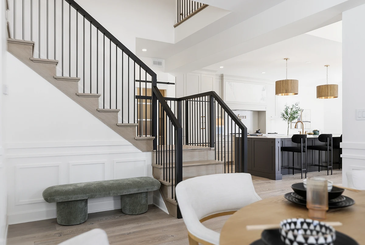 Contemporary staircase with black metal railings in a bright home.