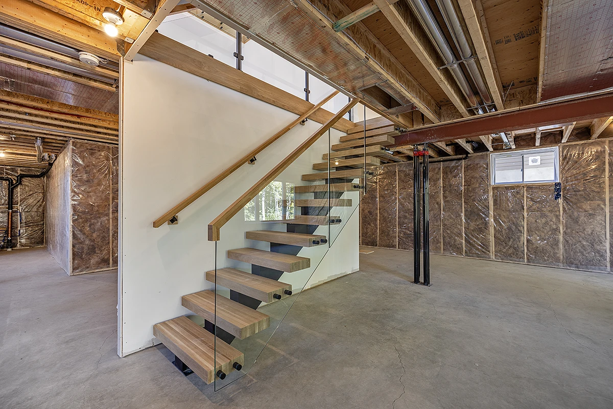 Floating staircase under construction with temporary wood railings.