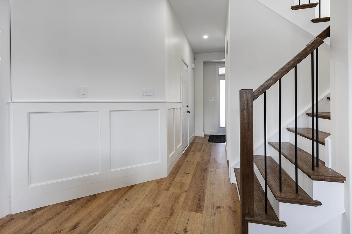 Contemporary staircase with black metal railings and hardwood flooring.