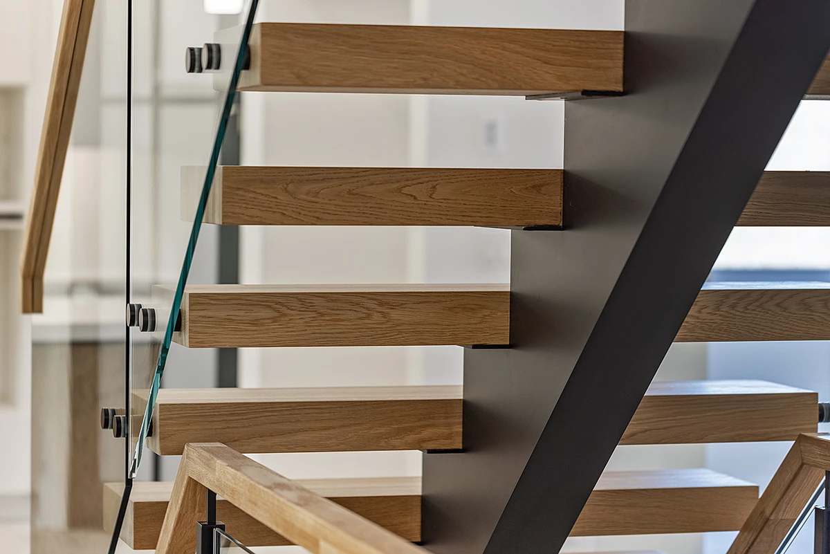 Thick floating oak stair treads on a black steel centre stringer.