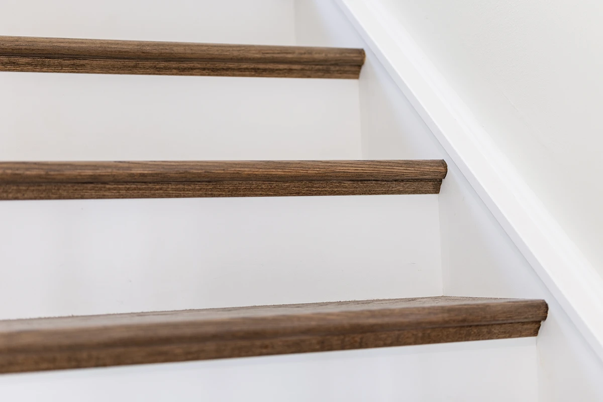Hardwood staircase with white risers and stained wood treads.