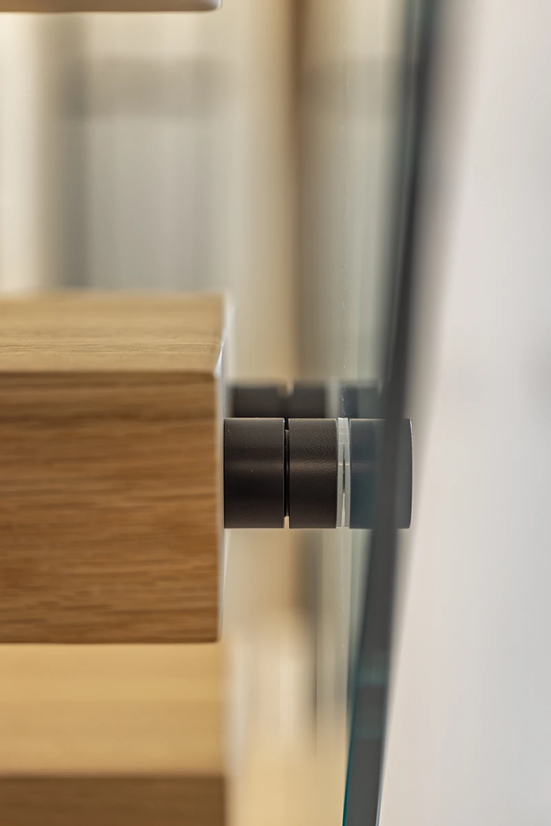 Close-up of hardware connecting the steel centre stringer to floating stair treads.