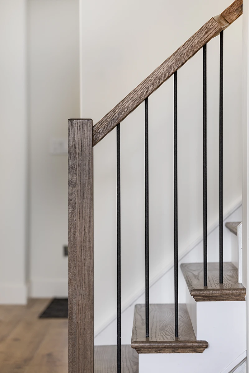 Square wood newel post with black metal balusters.
