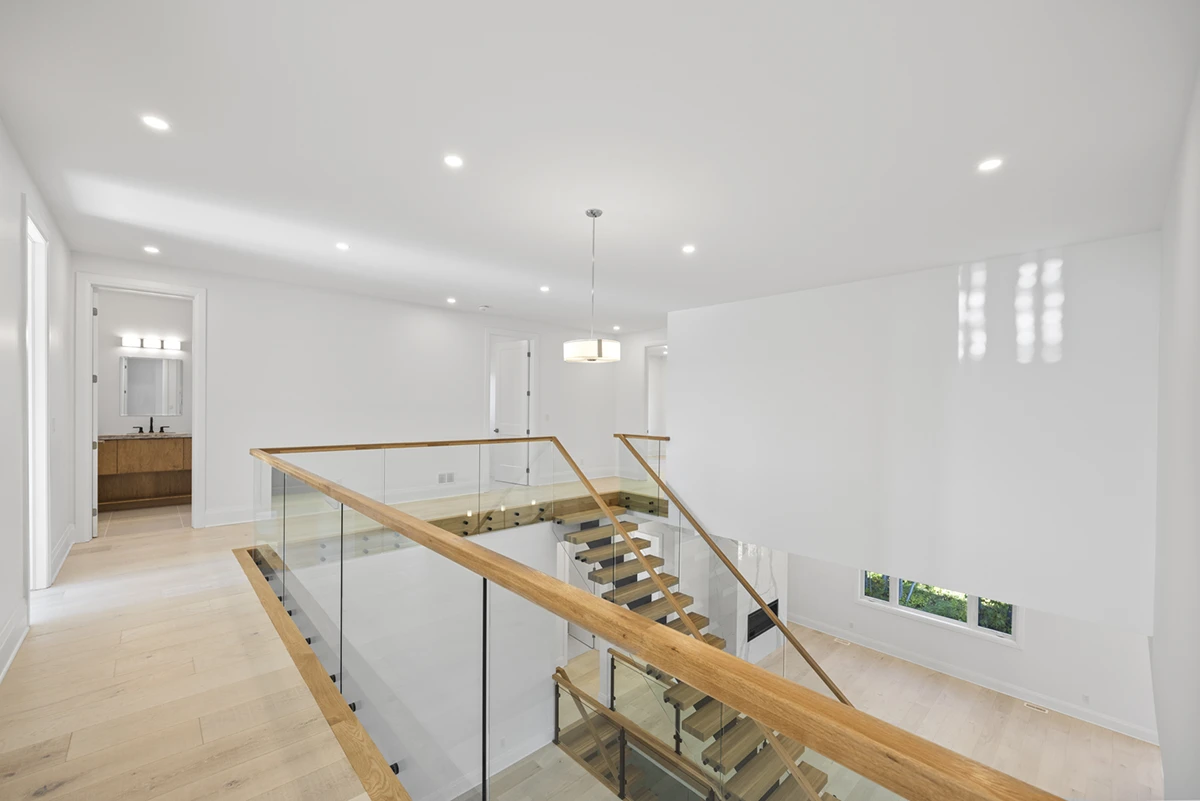 Floating staircase viewed from a bright upper landing.