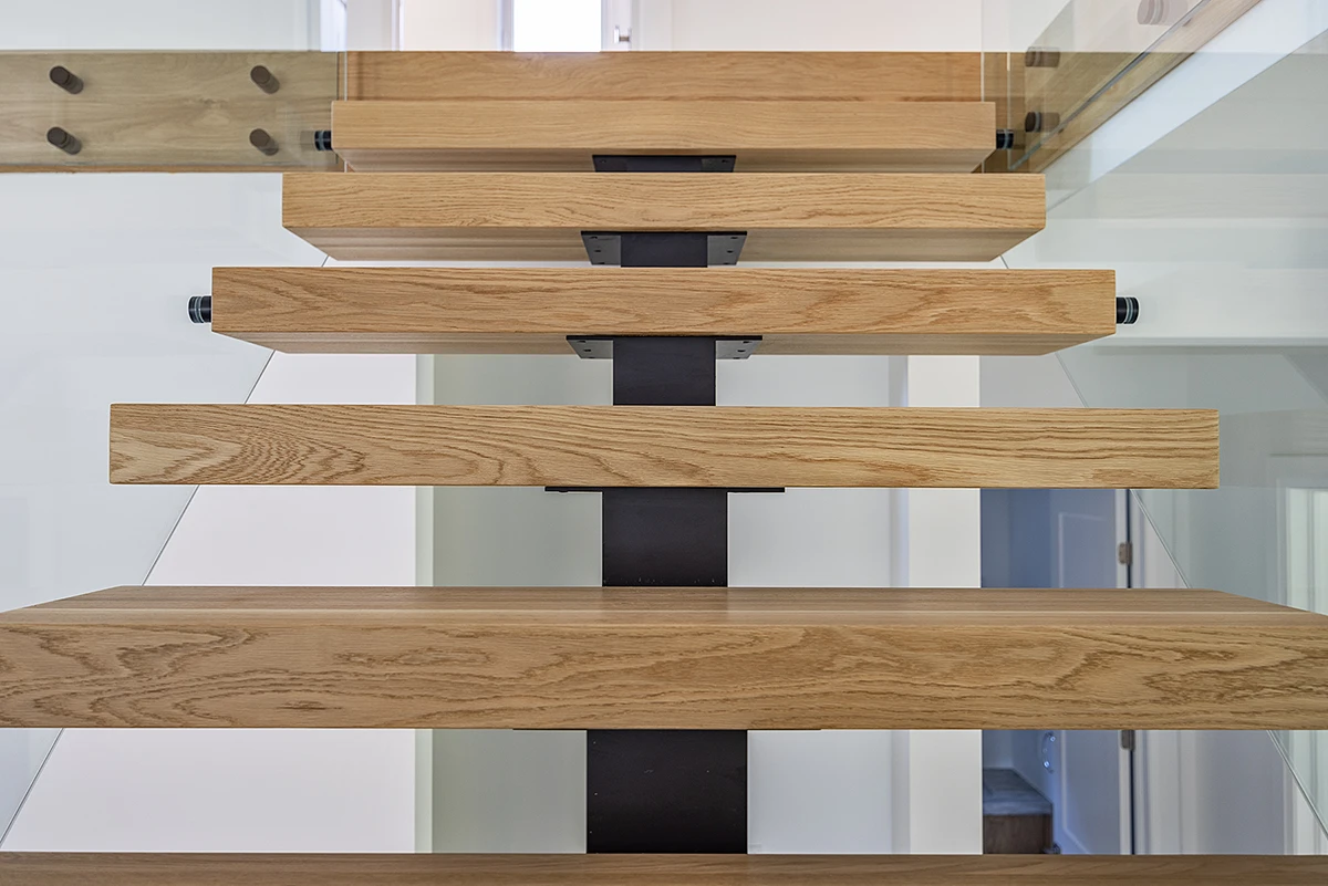 Front view of thick floating oak stair treads on a steel centre stringer.