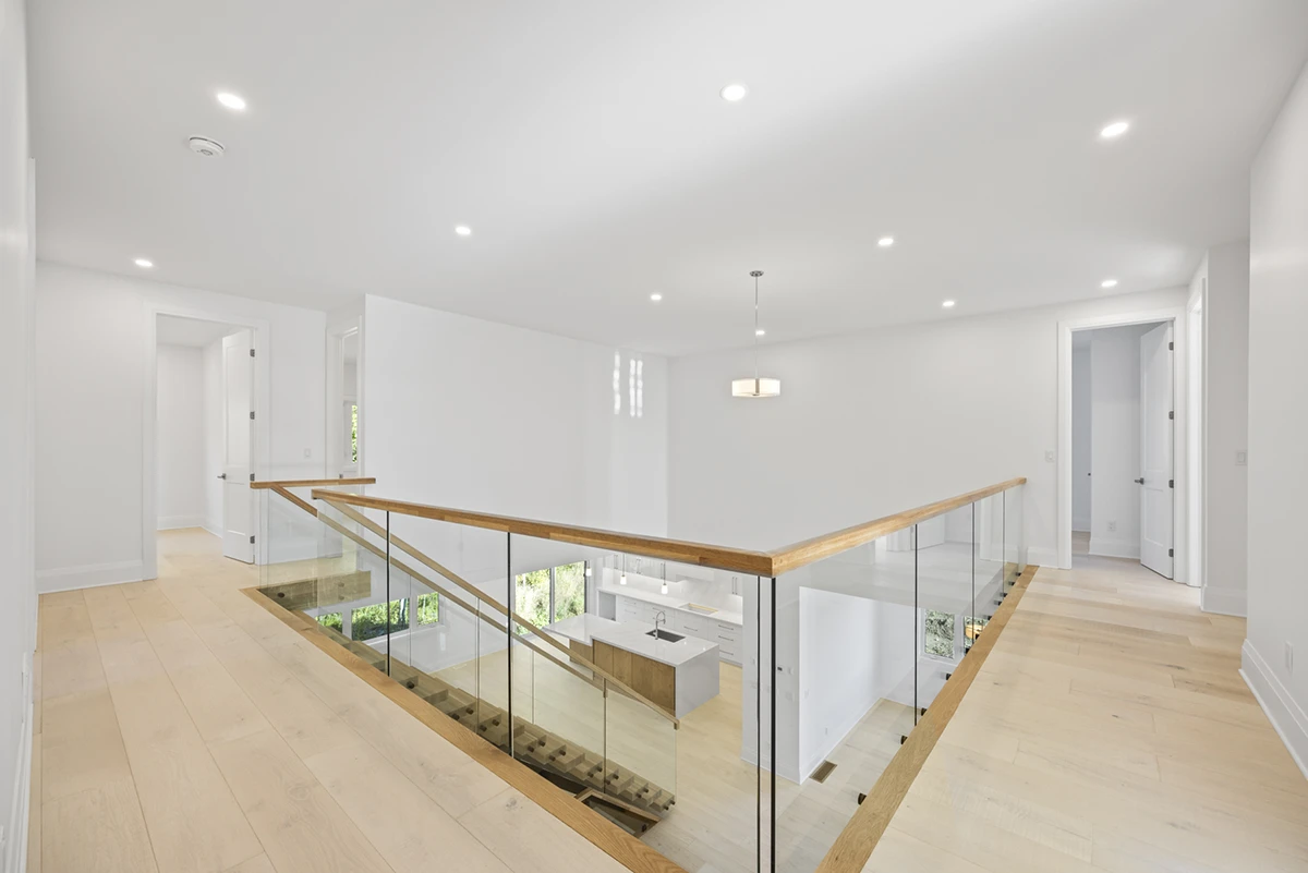 Floating staircase viewed from an upper level in a bright contemporary home.
