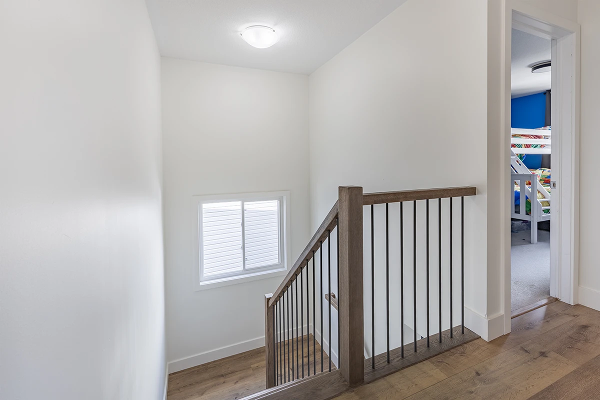 Residential staircase with black metal railings and wood handrails.