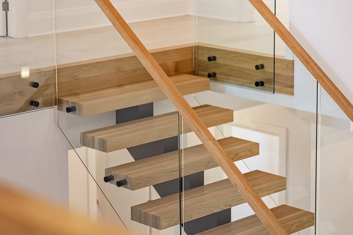 Overhead view of floating oak stair treads with glass railings.