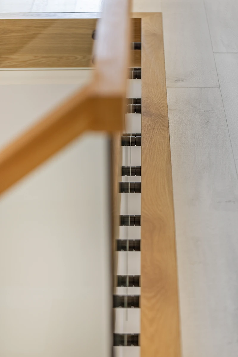 Wood handrail on a frameless glass floating staircase.