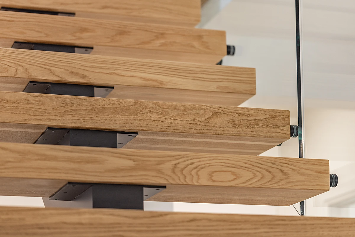Close-up of floating oak stair treads with a steel centre stringer.