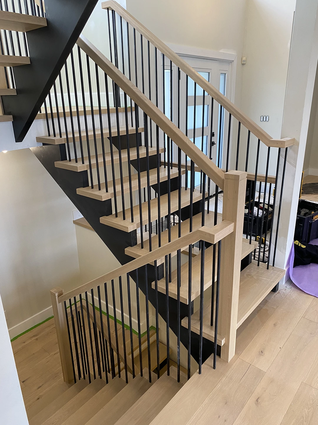 Finished staircase with new wood railings and balusters.
