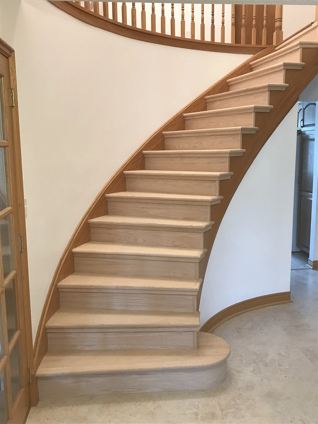 Finished curved staircase with restored wood.