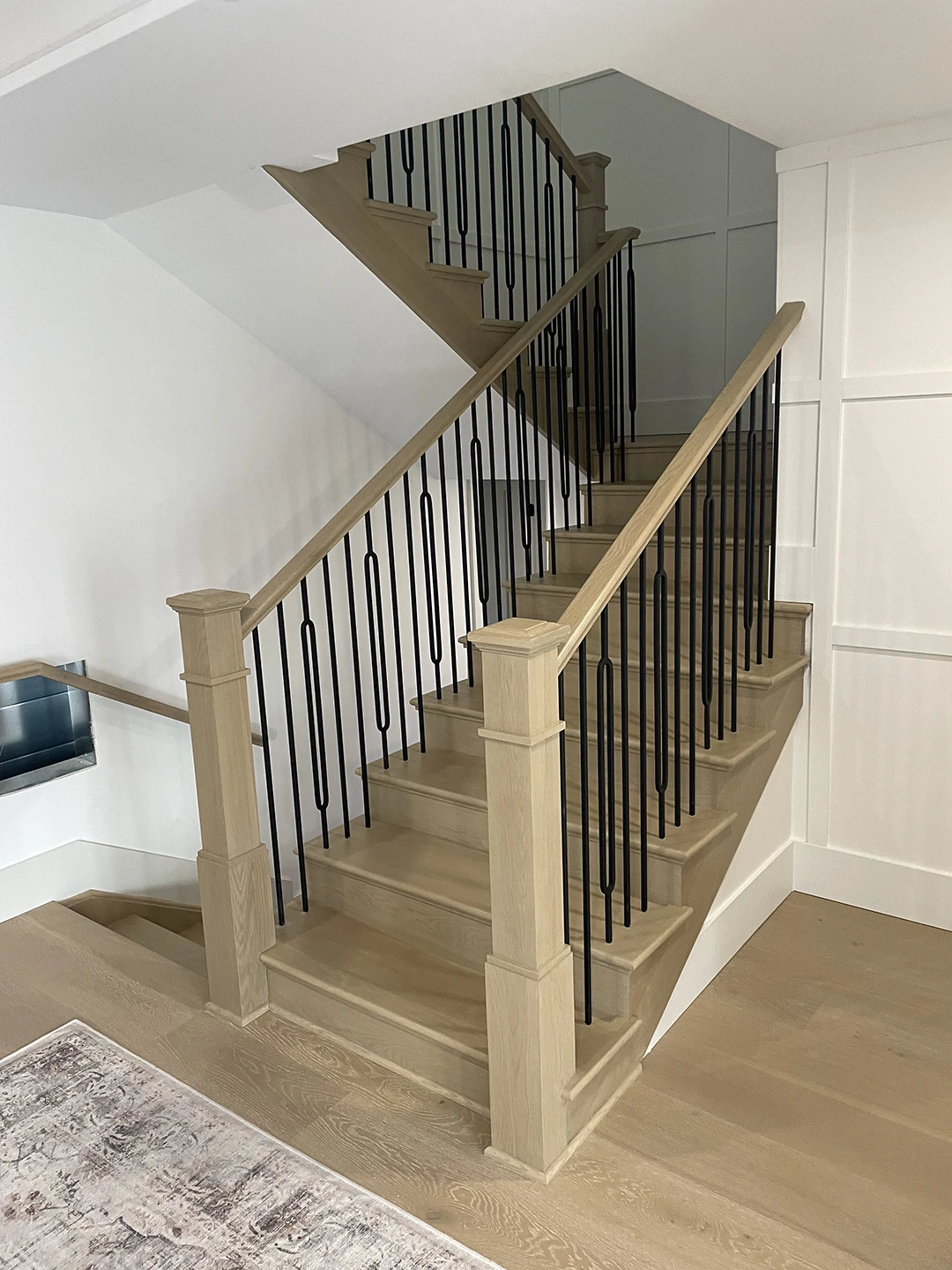 Refinished wood staircase with updated railings.