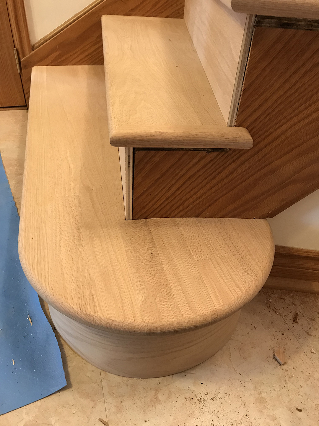 Close-up of refinished curved stair tread and railing.
