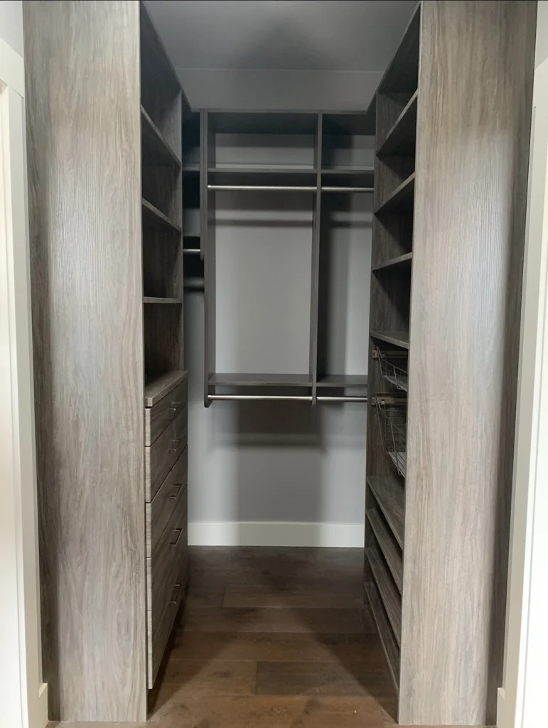 Walk-in closet with hanging storage and wood shelving.