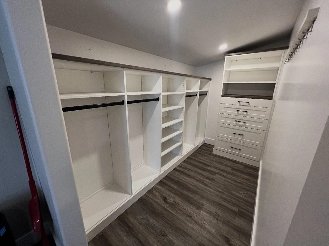 Custom walk-in closet with built-in shelving and drawers.